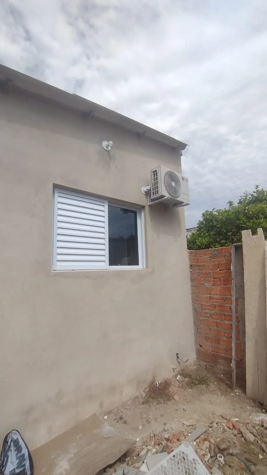 Unidade evaporadora de ar-condicionado split LG instalada em parede de quarto residencial
